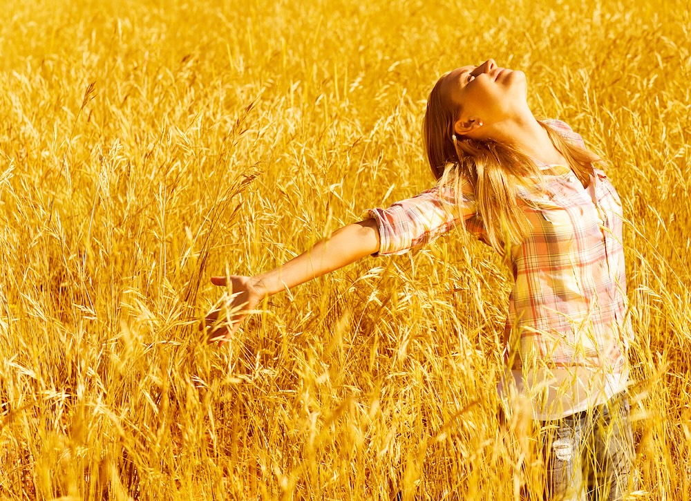 Girl in wheat field joyful